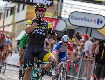 Dylan Groenewegen wielrennen met teken vinger voor mond stil zijn.